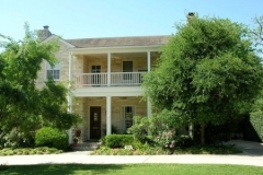 Limestone home with repainted porch, balcony railing and exterior board trims.