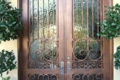 finished wood double entry doors with wrought iron and glass panels