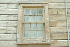 Weathered wood window and siding sanded to bare wood during paint preparation