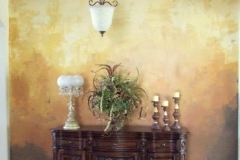 Hand-applied faux finish in gold and bronze tones on an entryway accent wall.